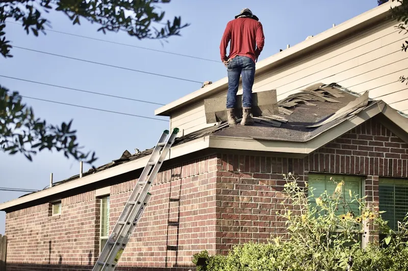 Professional roofer working on a residential roof in Keego Harbor